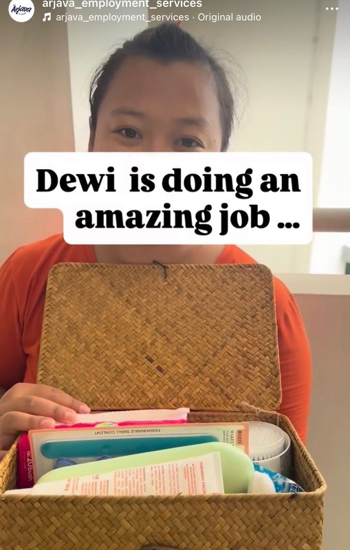 Dewi, a helper placed by Arjava, holding a token of appreciation from the agency